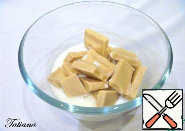 Melt white chocolate in hot milk. Let the chocolate-milk mixture cool.