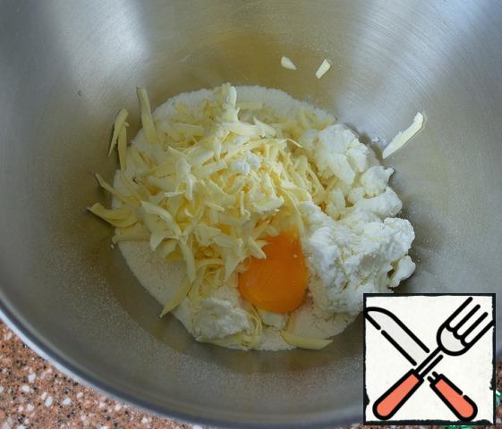 Grate cold butter, add cottage cheese and yolk.