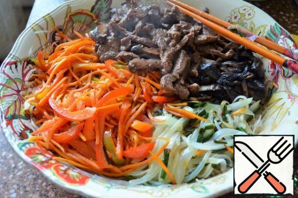Also quickly fry the mushrooms, separately pepper and carrots, add to the salad bowl.
The last to fry the meat, slightly pressing from the marinade. Put everything on the noodles.