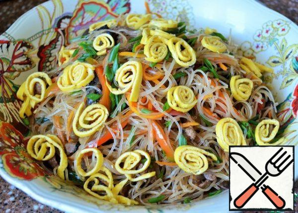 Add the dressing and gently mix everything in the salad bowl, more convenient with your hands. Garnish with yolk rolls and green onions.