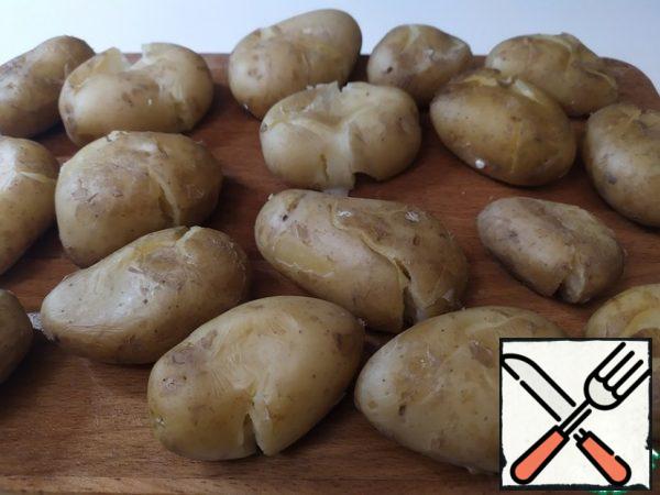 We'll take out the potatoes and hit each one with our fists to flatten them.