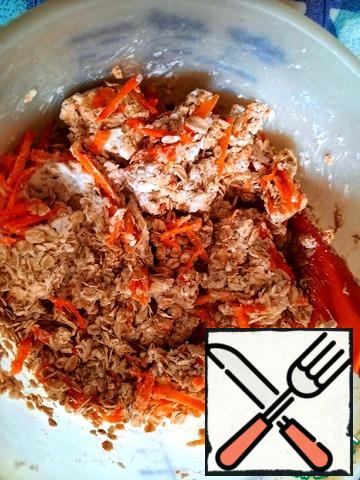Add soft cottage cheese, grated carrots and eggs to the oat flakes.