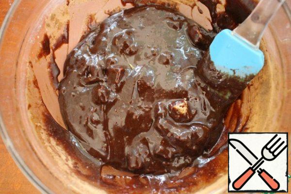 Using a silicone spatula, we mix the egg mixture into the chocolate one. Then add the cocoa and salt and mix thoroughly. At the end, we mix the chopped pieces of chocolate.