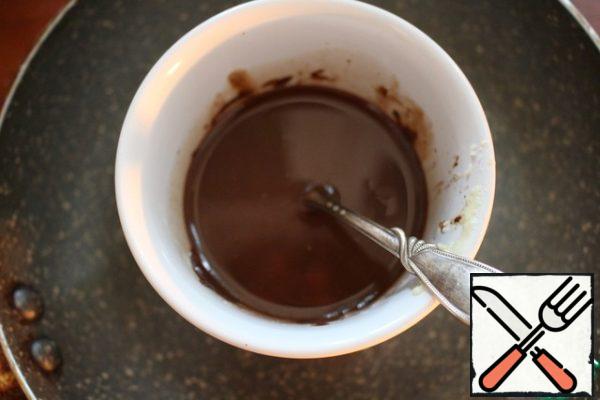 In a water bath or microwave, melt 120 g of dark chocolate with butter.