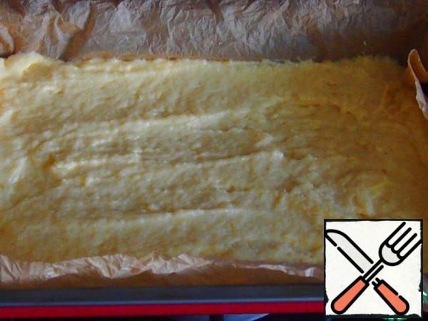 The form is covered with baking paper, the rest of the dough is placed in the form, spread on the bottom.
