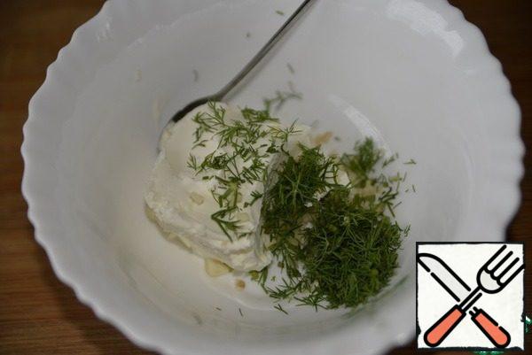 Curd cheese is mixed with chopped dill and garlic.