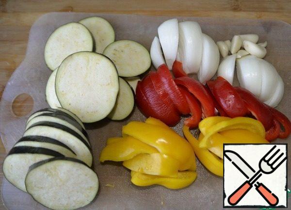 Vegetables are washed, cleaned, eggplant cut into rings about 7 mm thick, peppers and onions cut into segments. Leave the garlic whole.