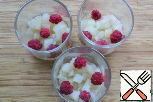 Drain the pears - do not pour out the juice - and put them in cups - I took 3 PCs with a capacity of 100 ml.
Put a few raspberries on top of the pears.