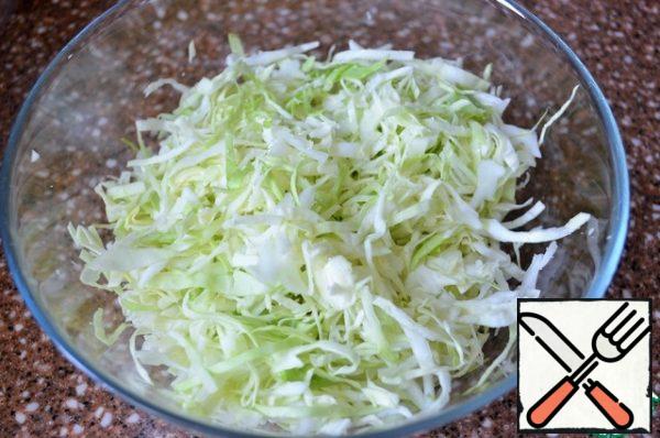 Shred cabbage finely, add a pinch of salt and sugar, slightly to grind by hand.