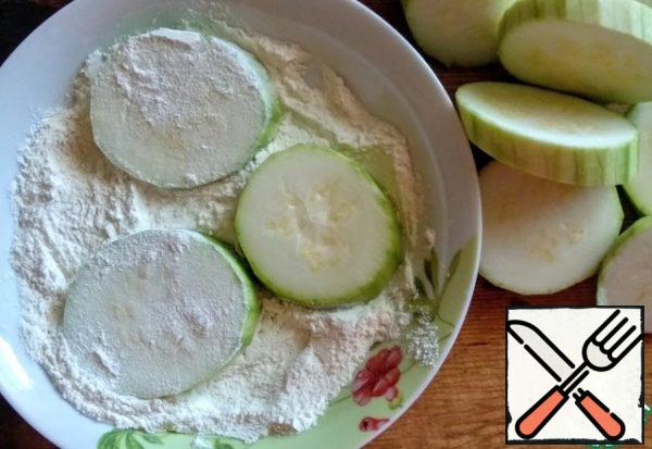 Wash the zucchini, peel it and cut it into circles. Unsuitable in size for future turrets to postpone. Roll the rest in flour (2 tbsp.), mixed with salt (1/4 tsp.)