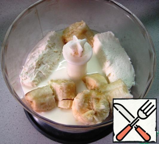 In the bowl of a blender, combine sweet, vanilla curd, kefir, powdered sugar and banana slices.