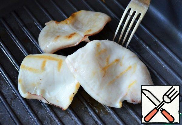 Cook the squid. Cool, blot, and grease with vegetable oil
and fry in a grill pan. Slice them thinly.