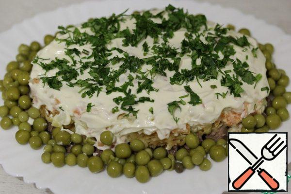 Before serving, grease the salad with a small amount of mayonnaise, garnish with herbs and peas.