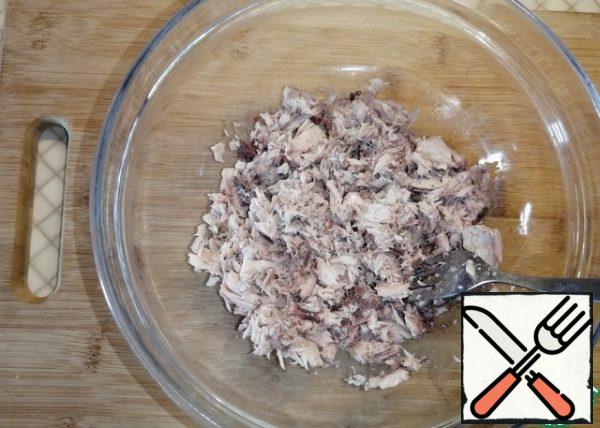 In a deep bowl, mash the tuna, draining all the liquid before doing so.