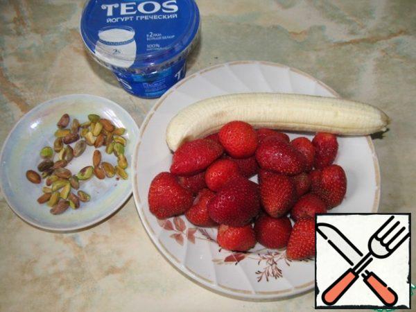 To prepare the products. Peel the banana, wash the strawberries and remove the tails.
Chop the pistachios.