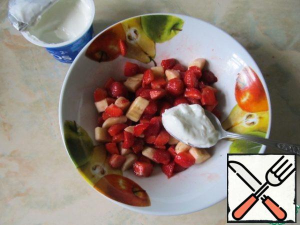 Mix the strawberries with the banana and add the yogurt. Mix again.