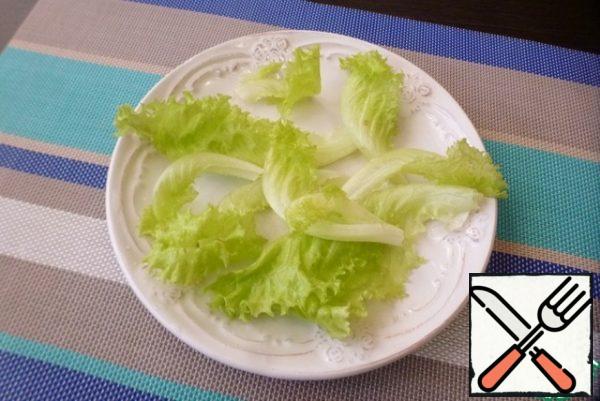 Now we collect the salad. Put the lettuce leaves on a plate.