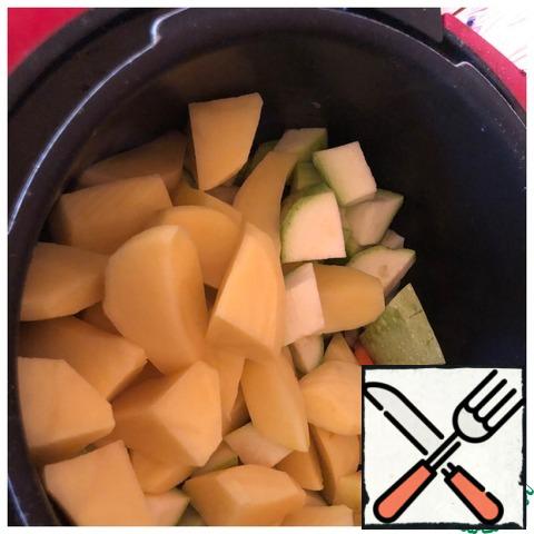 Peel the potatoes and cut them at random quite large, and cut the zucchini into medium pieces.