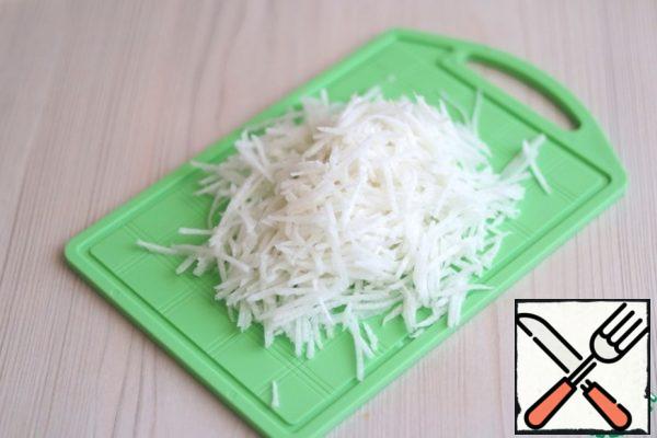 Chop daikon (1 PC.) on a grater for cooking Korean salads with a small section.