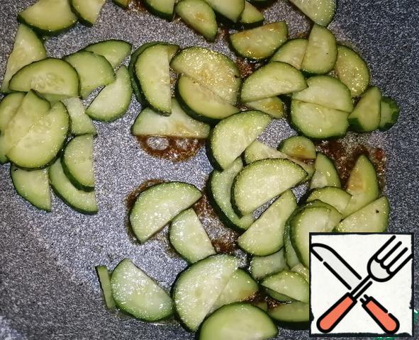 Add 0.5 tbsp of vegetable oil to the pan where the chicken fillet was fried and pour out the cucumbers. Fry for 3-4 minutes. Add soy sauce and salt to taste. Fry for another 3-4 minutes over medium heat, stirring occasionally. Cucumbers are ready to pour into the dish with the fillets.