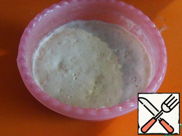 In a bowl, mix half of the warm milk with yeast, sugar and three tablespoons of flour. Put in a warm place until the cap is formed.