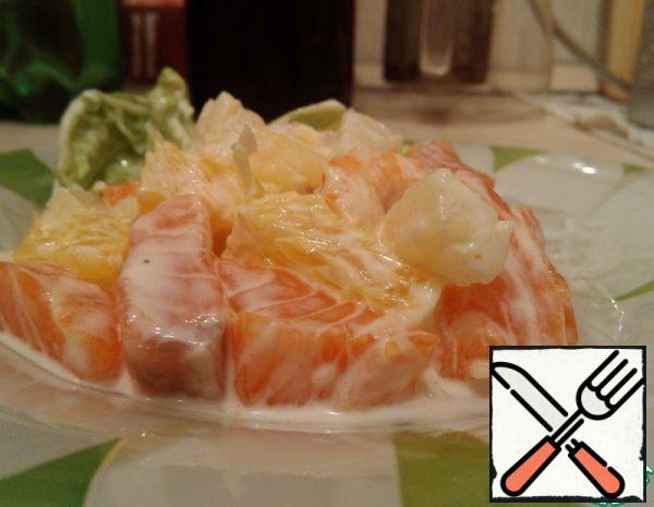 Fillet of fish cut into cubes about 1, 5x1, 5 cm.With pineapples (canned pieces), drain the water, add the desired amount to the fish.Oranges are peeled, cut out only the flesh without partitions. Also cut into cubes 1x1 cm (approximately), add to the fish with pineapples.Boil the prawns, peel them from the shell, and add them to the rest of the ingredients.Preparing the sauce: pour soy sauce into the mayonnaise, add garlic, grated on a small grater or passed through a press. Carefully mix the sauce.
Add the sauce to the salad, mix a little. No additional seasoning is necessary, and no salt is necessary.
Decorate with green leaves (pekinka or arugula).