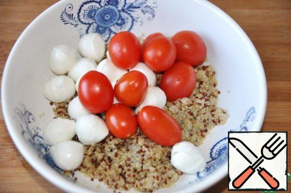 Add mini mozzarella balls and cherry tomatoes to the quinoa.