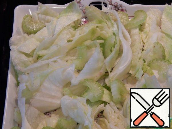 Cut the salad and put it on the bottom of the salad bowl, cut the celery into strips.