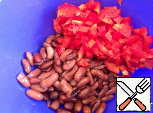 Drain the excess liquid from the beans. Cut the pepper into cubes.