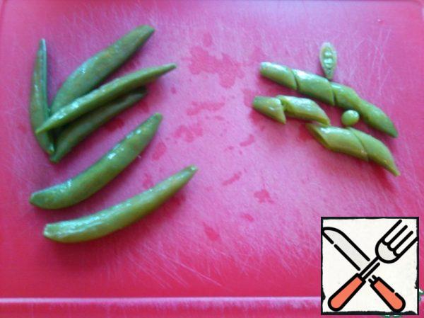 Put the pea spatulas in boiling water for 1 minute and immediately cover with cold water (if you have fresh ones).
Or defrost (if frozen).
And cut it diagonally, send it to the vegetables.
