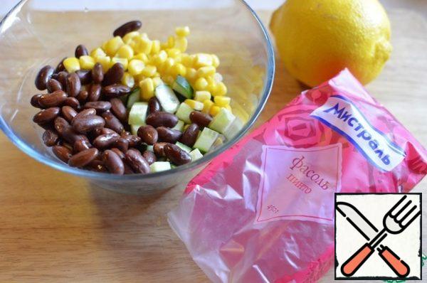Mix the beans, greens, cucumber, and corn in a bowl. Squeeze out the lemon. Lightly season with sea salt.