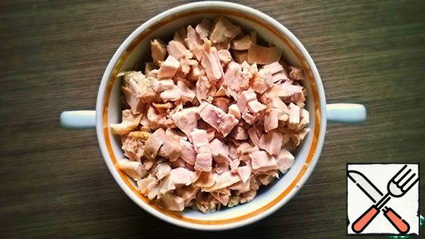 Cook the chicken and chop it. You can use the meat of baked or smoked poultry.
