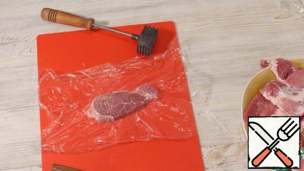 Dry the meat with paper towels. Cut into slices about 1 cm thick. I have a shoulder blade, you can take carbonade or tenderloin. We will beat off each piece, covering it with a film so that no splashes fly. Salt and pepper.