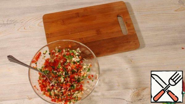 For the filling, finely chop the onion, half the pepper, part of the greens, and garlic. Sprinkle with salt and stir. You can add adjika, hops-suneli, utsho-suneli to the filling.