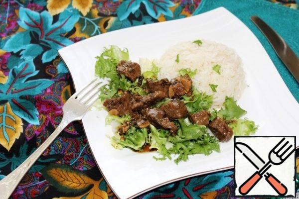 We put salad leaves on plates, meat on top, and boiled rice as a side dish.