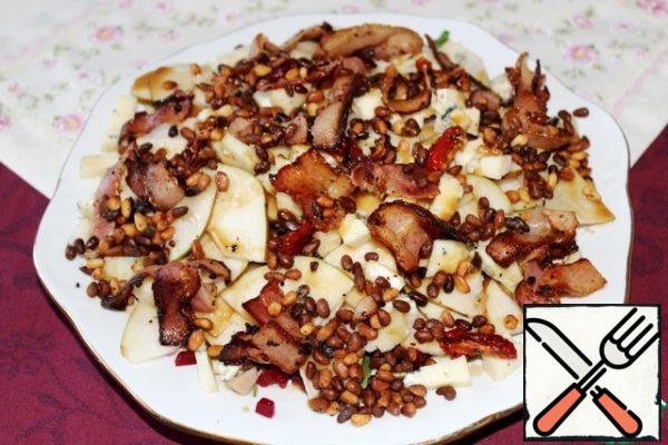 Top the salad with nuts and bacon, pour the dressing. I advise you not to use the entire dressing, but to serve the leftovers separately, so that those who wish can add to their taste.