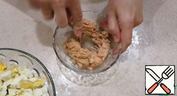 Drain the oil from the tuna and mash it with a fork.