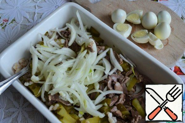 Add the cucumbers and the onion that has been strained from the vinegar.
Peel the eggs and cut them into halves.