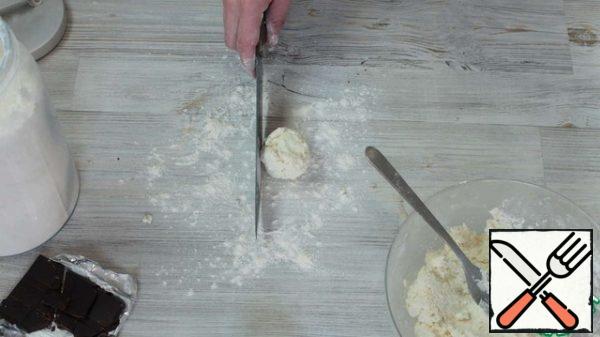 Then we dust the table with flour and shape it. In order to form beautiful and smooth sides of cheesecakes, do the following: put the cheesecake on the table and scroll it, between the knife and the flat part of the blade) and the hand and slightly pressing.