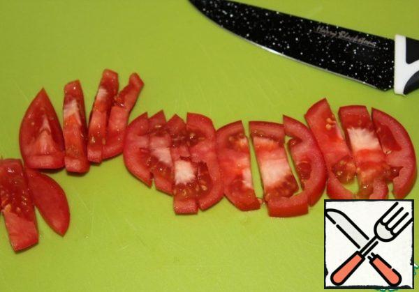 Cut the tomato into strips. Wash the greens under running water.