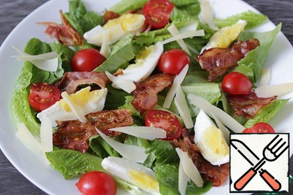 Sprinkle the salad with cheese petals. Season the yogurt with salt, pepper and a pinch of sugar.
Serve the salad, watering it with dressing.