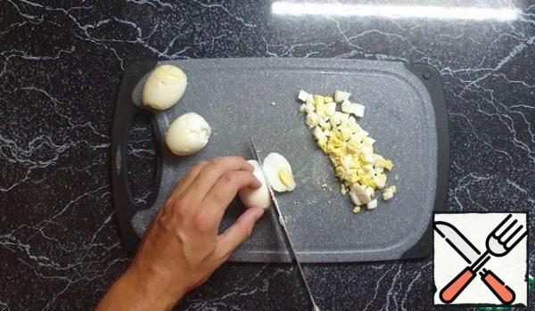 Next, boil hard-boiled eggs and also cut into small pieces.