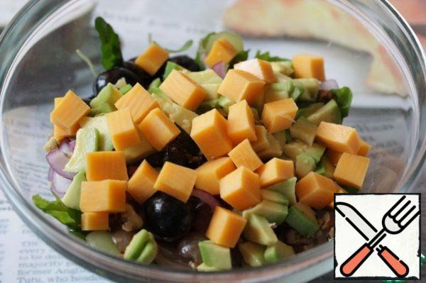 Peel the avocado, cut it into cubes, sprinkle it with lemon juice and add it to the salad.