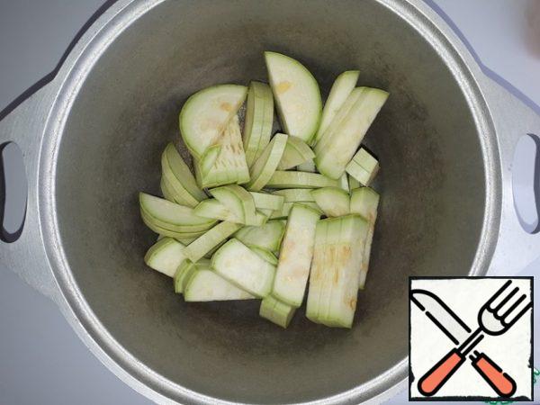 Put the sliced zucchini pieces in the cauldron.
