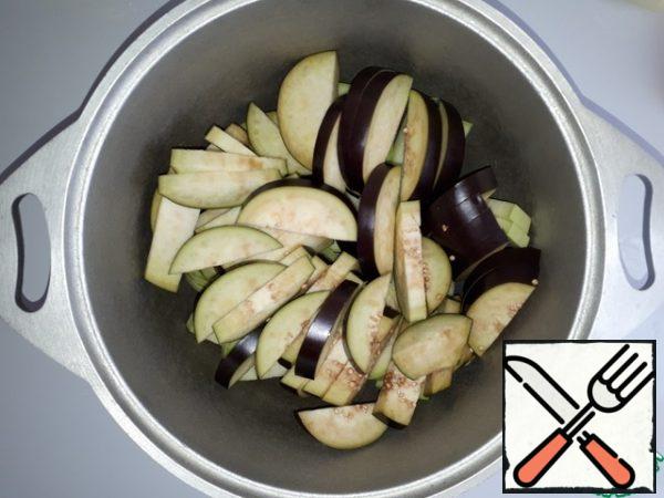 Add the sliced eggplant to the courgettes in the cauldron.