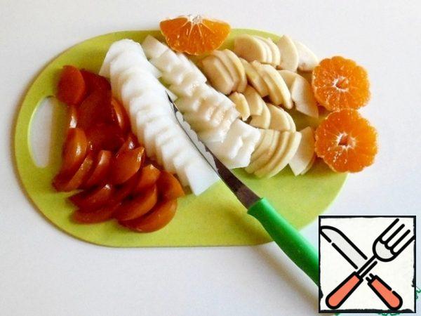 Wash and dry the persimmon. Carefully cut into 4 parts lengthwise. Remove the bones and cut into plates. Also cut the apples and melon.
Cut the tangerines in half across. Divide into slices.