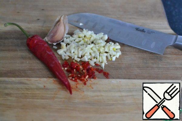 Finely chop the garlic and chili peppers.