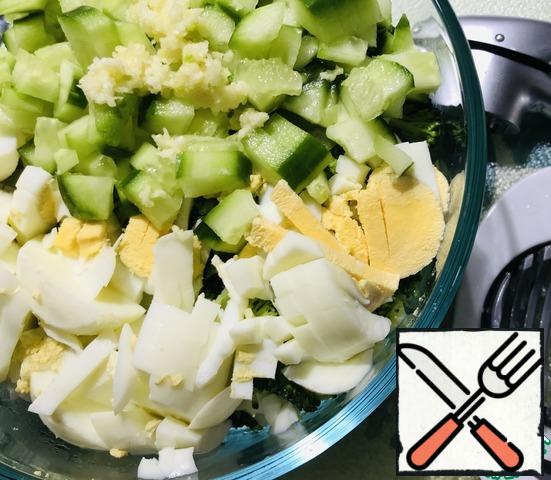 When the broccoli is boiled, drain, cool slightly, cut into small pieces, peel the eggs, cut through an egg slicer, squeeze the garlic through a garlic press, cut the fresh cucumber into cubes, put 4 tablespoons of Greek yogurt. Add salt to taste before serving.