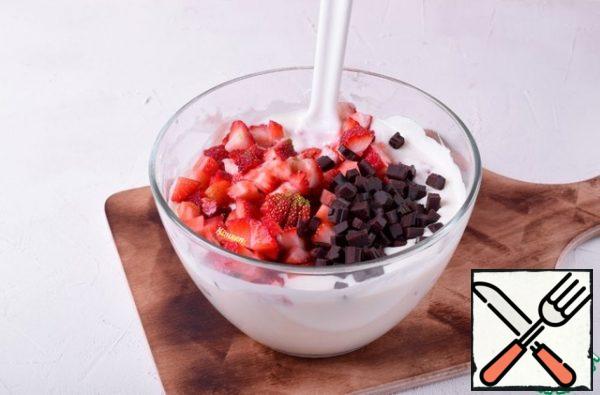 To the mixture of cottage cheese and powdered sugar, add the kefir-gelatin mixture, mix.
Add the whipped cream and mix again.
Last of all, put the pieces of strawberry and chocolate, mix everything with a spatula.
