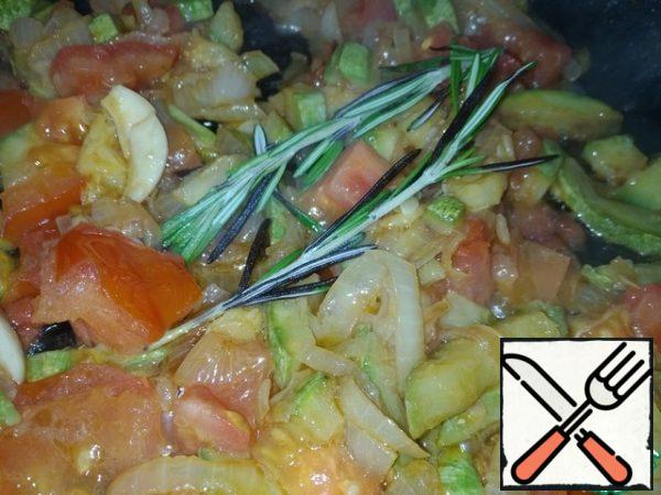 In a preheated pan, pour a little sunflower oil and fry the onion and zucchini. After a couple of minutes, add the crushed garlic, chopped tomatoes and rosemary branches.